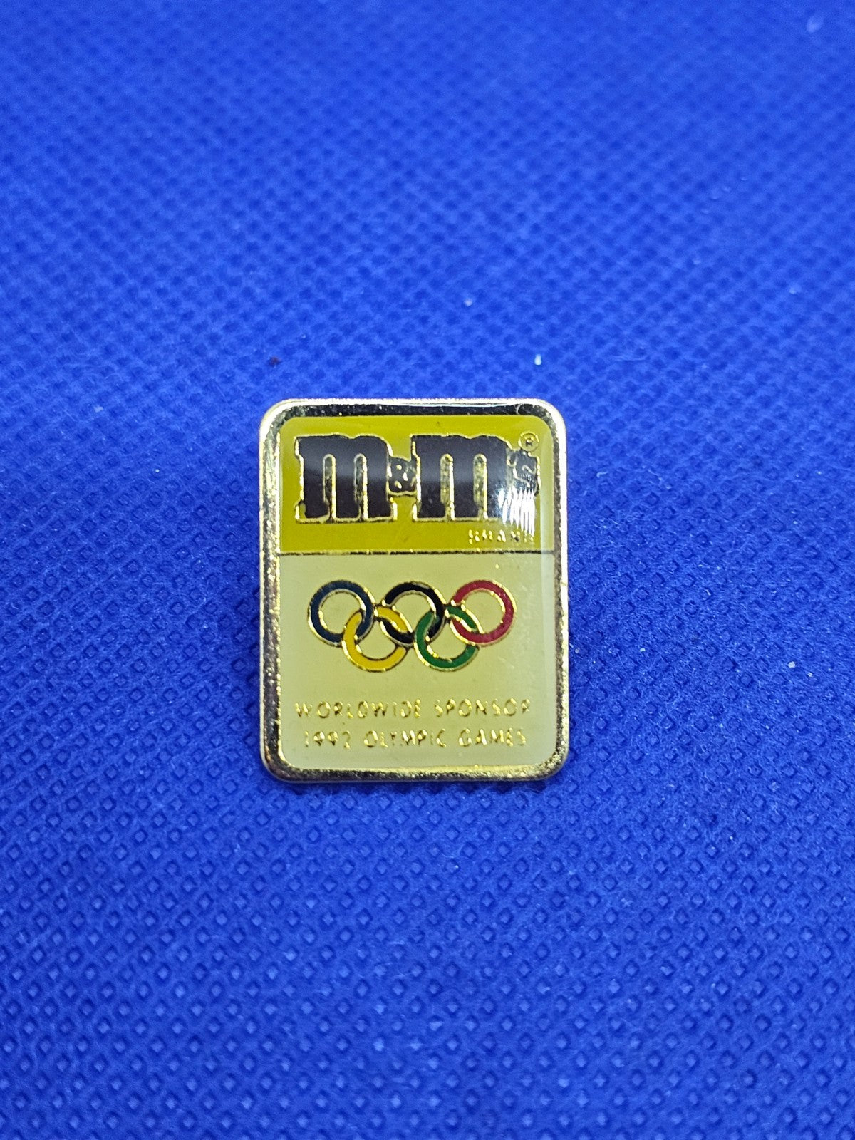 Pin’s M&M’s Sponsor Jeux Olympiques 1992 Mars Anneaux Olympiques0